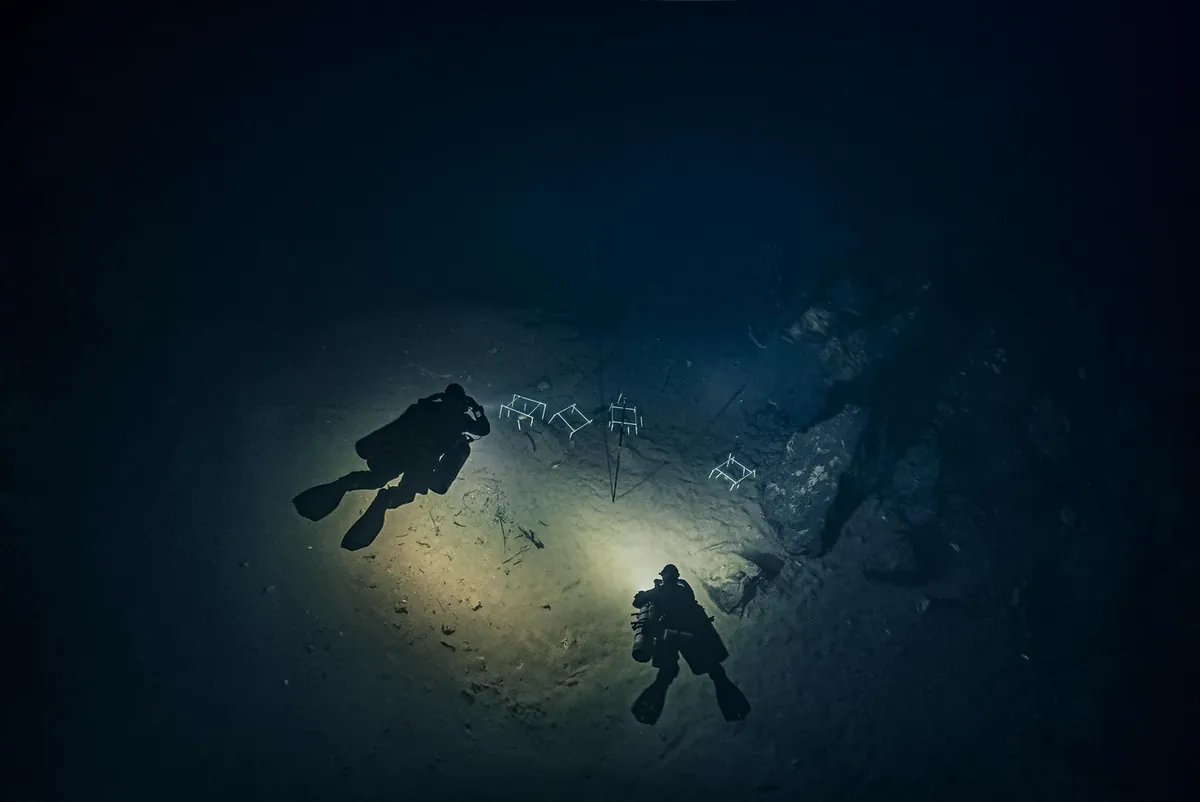 Green Cave Sink 6 seen from above, two divers lighting the floor with the diffuser on